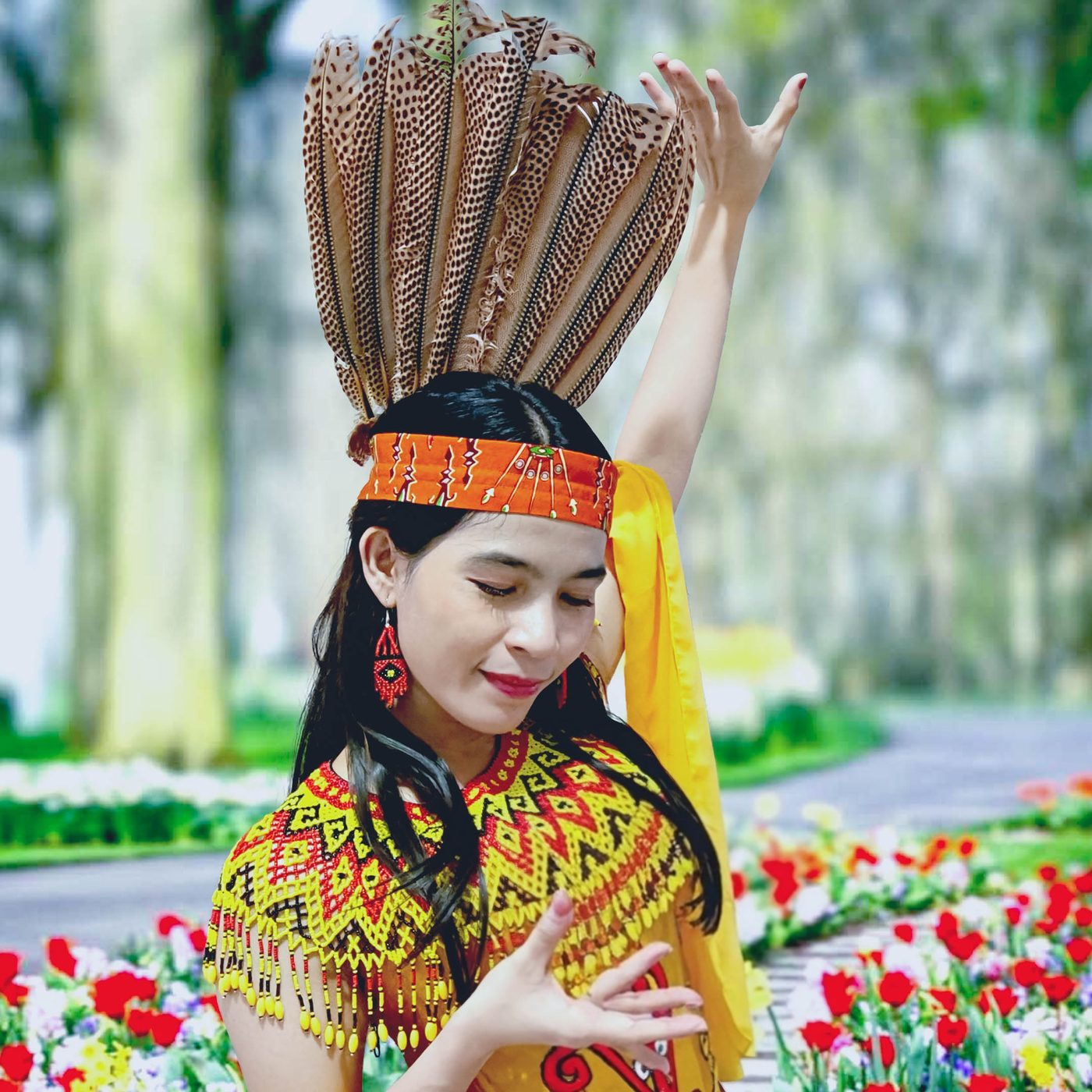Model Veina Skincare mengenakan busana adat Dayak di taman berbunga
